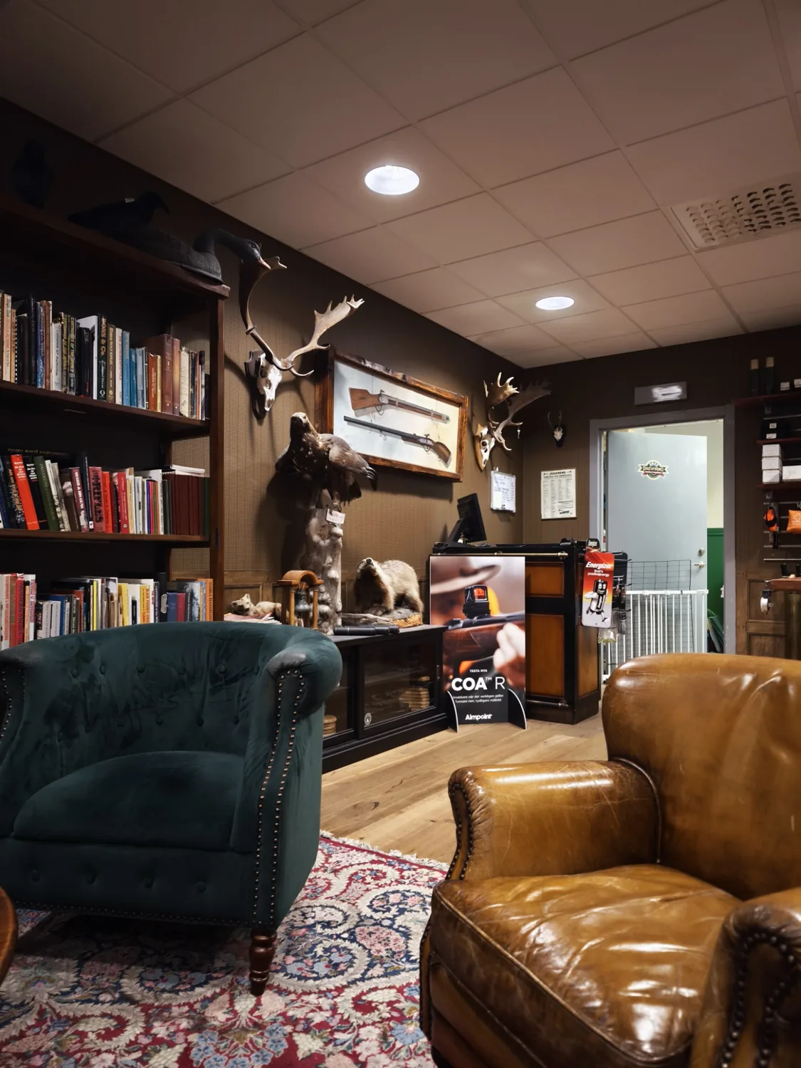 Gröna fåtöljer och bokhyllor i butikens salong